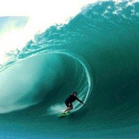 Фотография известный серфер на больших волнах Майя Габейра едет в большой трубе