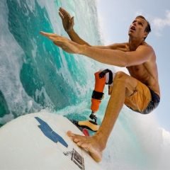 Фотография серфер без ноги Майк Кутс едет по волне